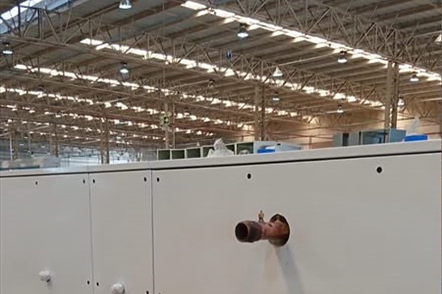 Linha de equipamentos de climatização montada no piso da fábrica, sob a estrutura metálica do galpão