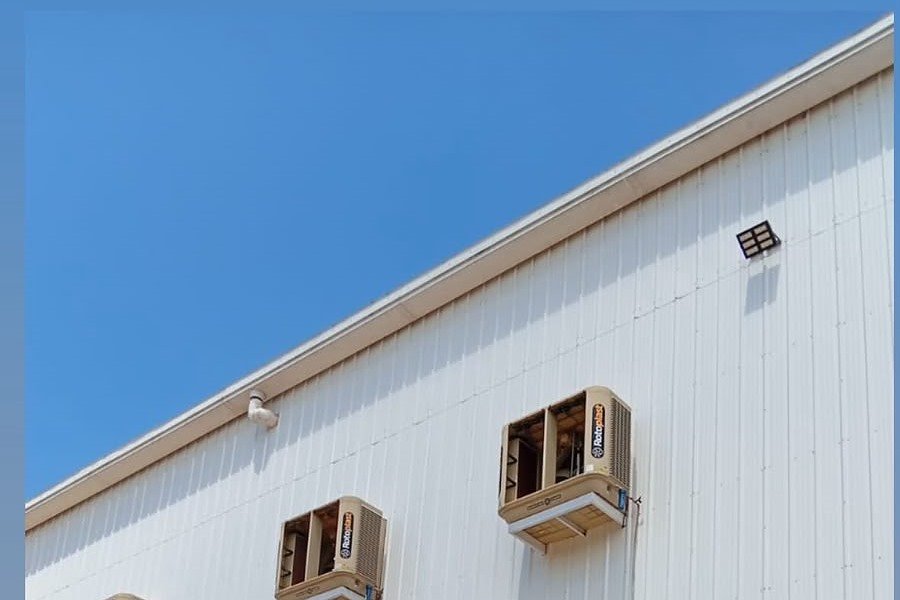 Climatizadores instalados na fachada do galpão industrial, vistos de baixo